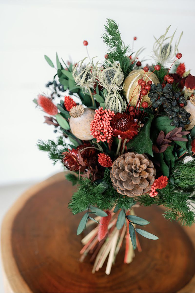 Bouquet of winter dried flowers with pinecones and berries