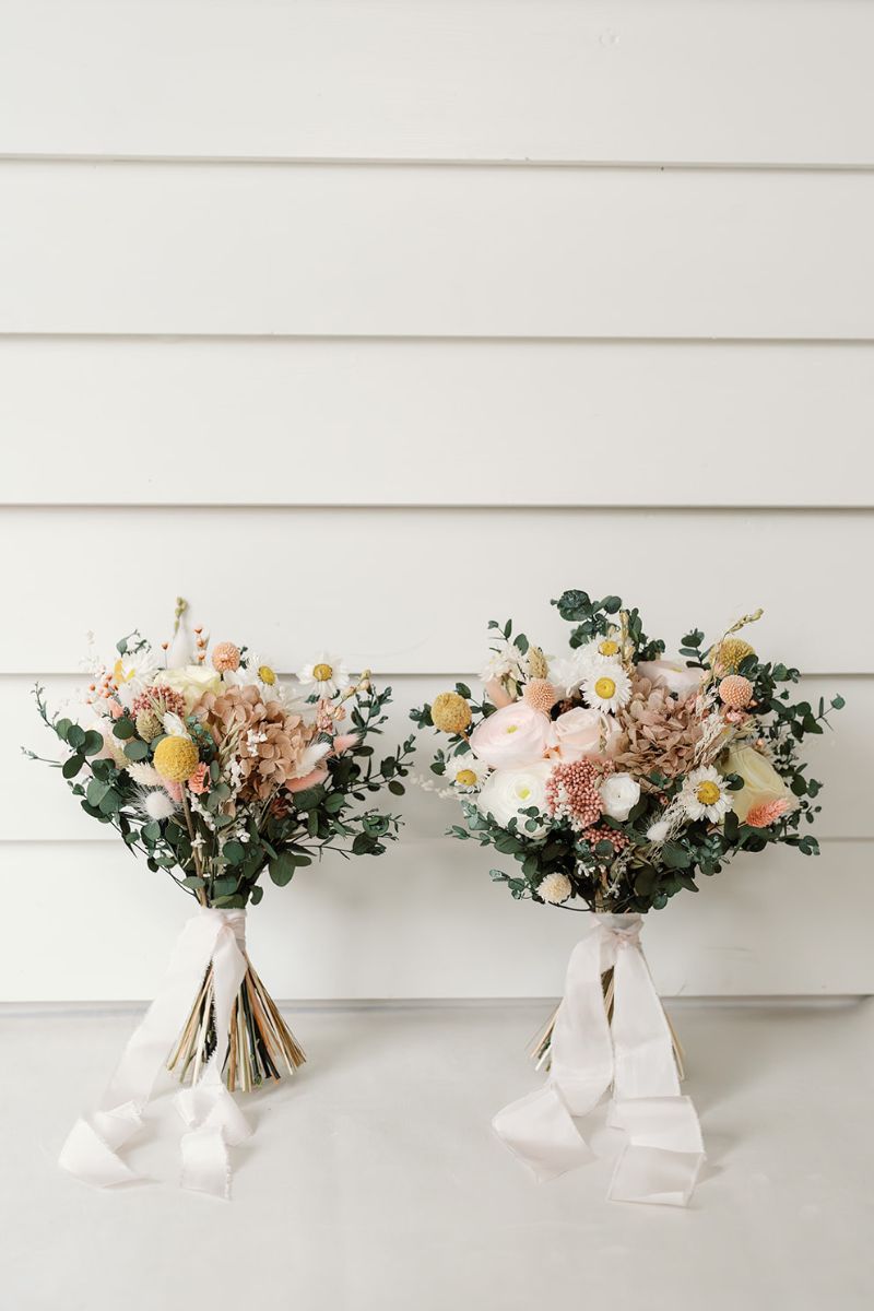 Bride and bridesmaids size garden inspired dried and preserved flower bouquets in lemon, pale pink, white and green