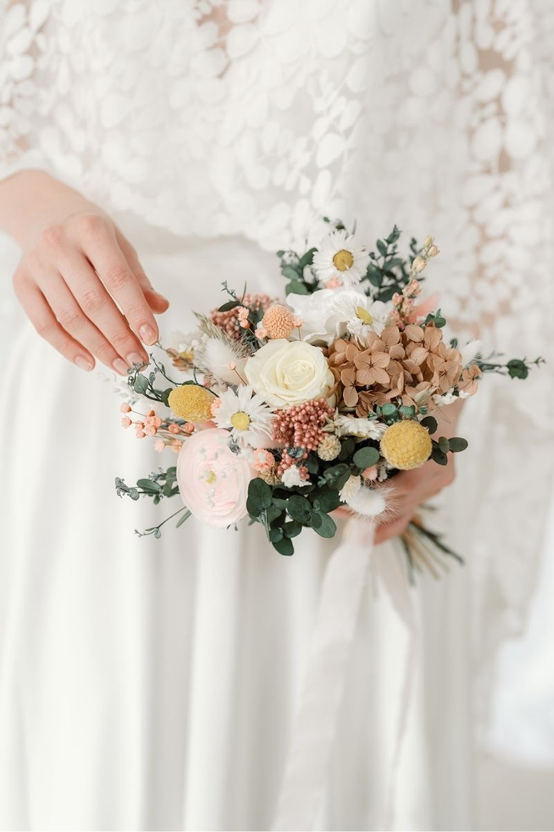 Bridesmaid size Cora garden style dried an preserved flower bouquet in pink, lemon and white tones with lush greenery by Luna and Wild.