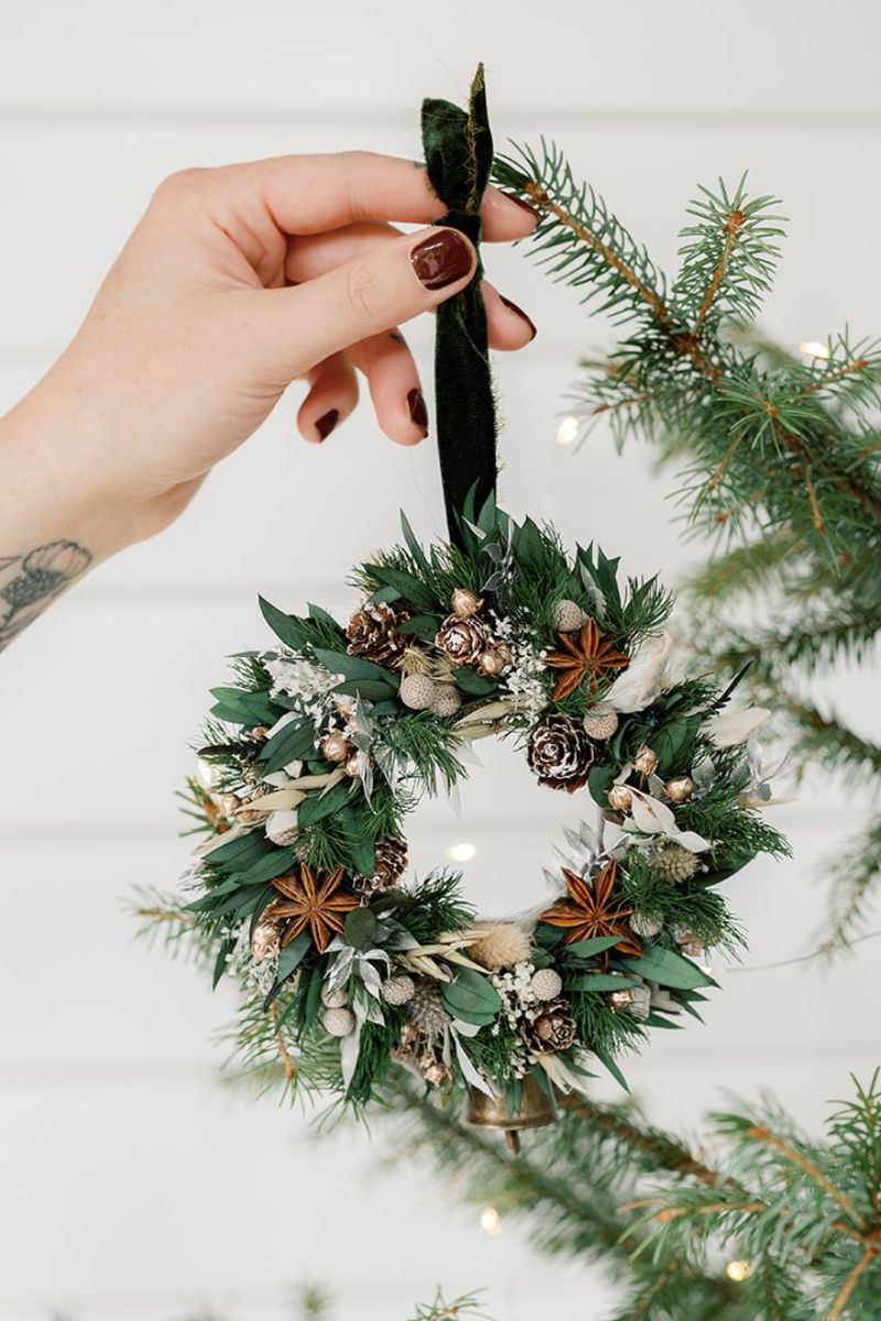 small decorative wreath bauble with pinecones and green velvet ribbon.