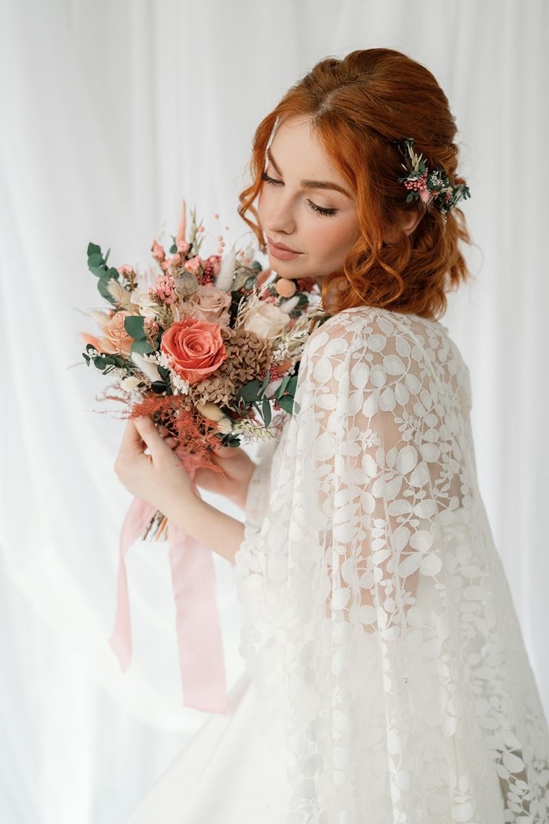 Wildflower style dried flower bridal bouquet featuring coral pink, white and nude flowers with lush greenery and fluffy ferns