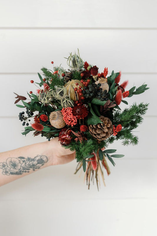Festive dried flower bouquet in reds, greens and blue.