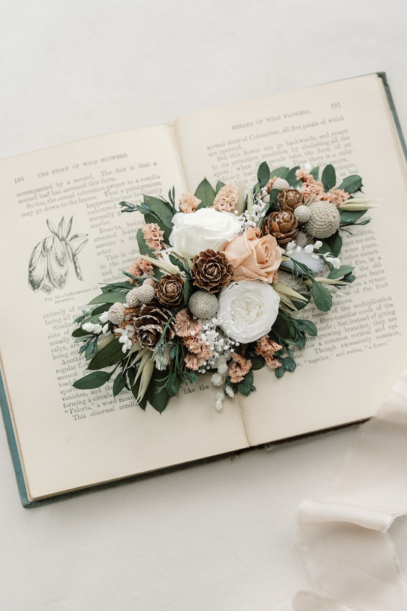 Inspired by frosty mornings, this winter whites wedding dried flower hair clip features preserved roses in nude and white, surrounded by lush foliage and silver berries.