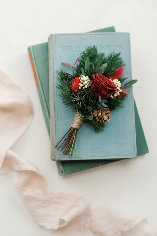 Dried and preserved winter wedding grooms buttonhole with preserved red rose and lush green ferns, a traditional colour scheme with a fresh bohemian twist by Luna and Wild.