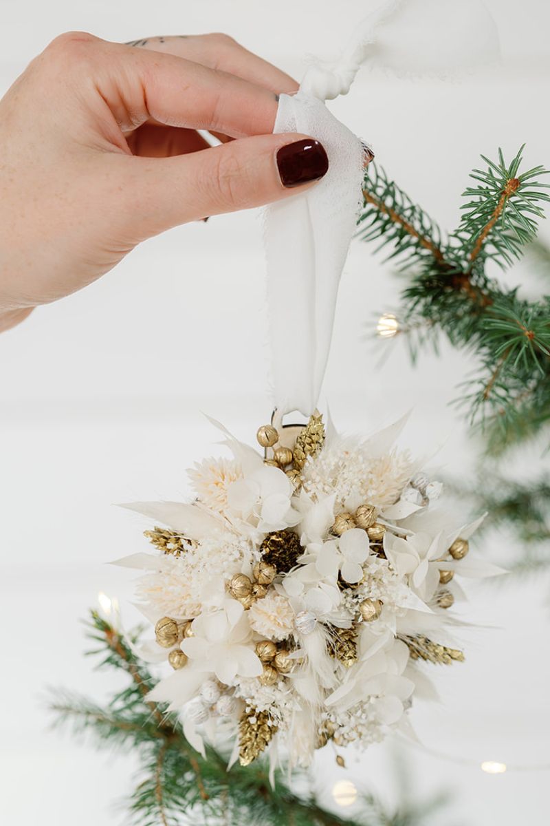 A decorative ornament with white flowers and gold accents