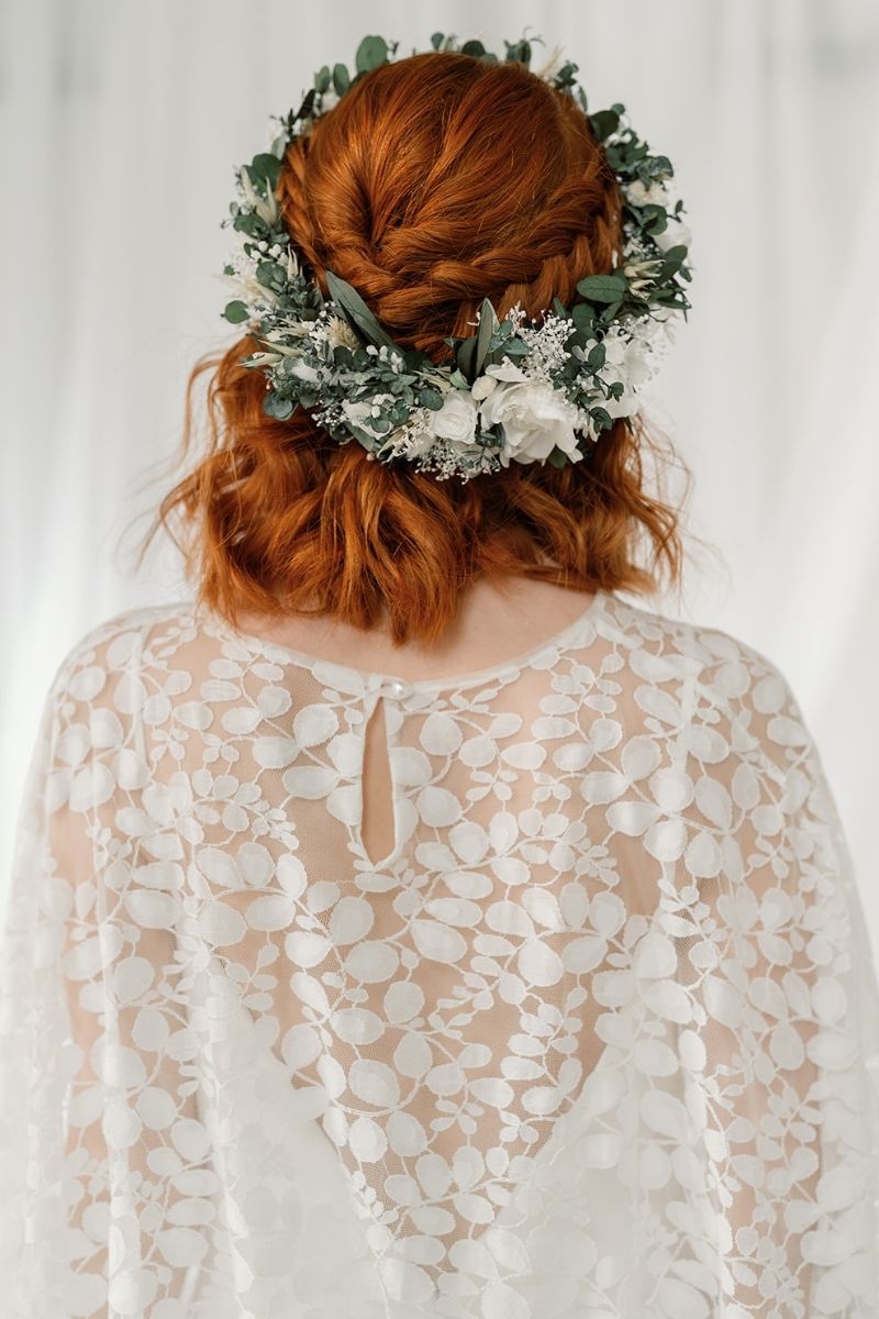 green and white full circular dried flower crown with a focal arrangement of white roses and hydrangea.