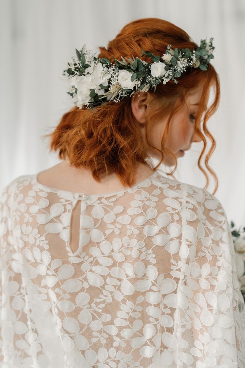 green and white full circular dried flower crown with a focal arrangement of white roses and hydrangea.