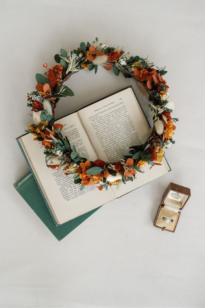 Autumnal dried flower crown with mini peach preserved roses, pine cones, daisies, straw flowers and eucalyptus, a full circular crown.