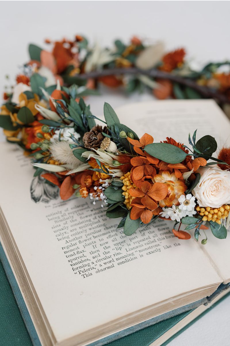 Autumnal dried flower crown with mini peach preserved roses, pine cones, daisies, straw flowers and eucalyptus, a full circular crown.