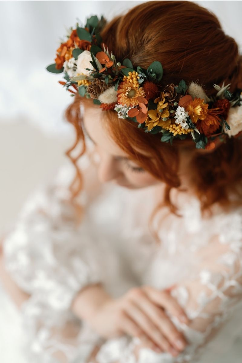 Autumnal dried flower crown with mini peach preserved roses, pine cones, daisies, straw flowers and eucalyptus, a full circular crown.