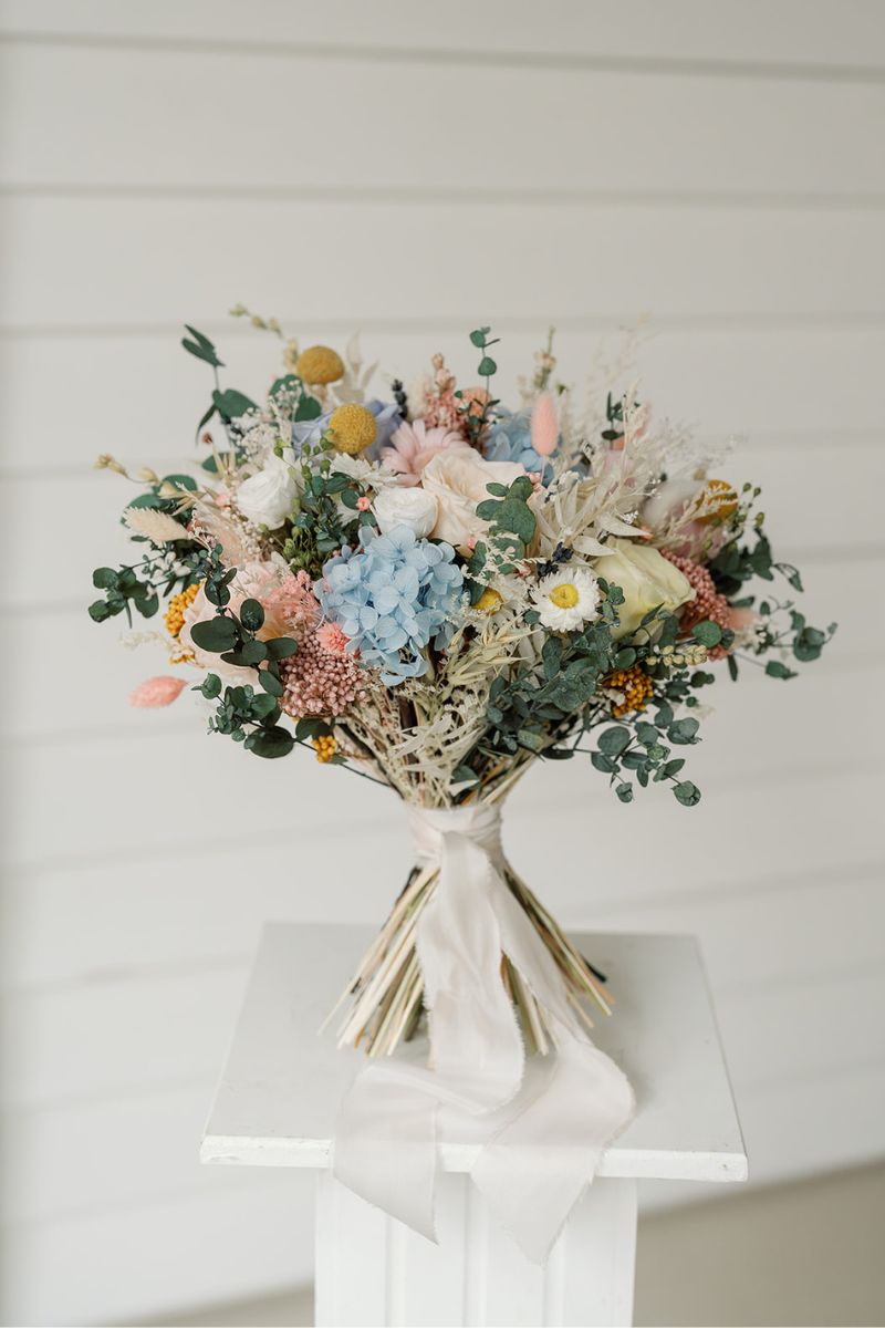 Pastel garden style dried and preserved bridal bouquet with roses, daisies, hydrangeas and eucalyptus