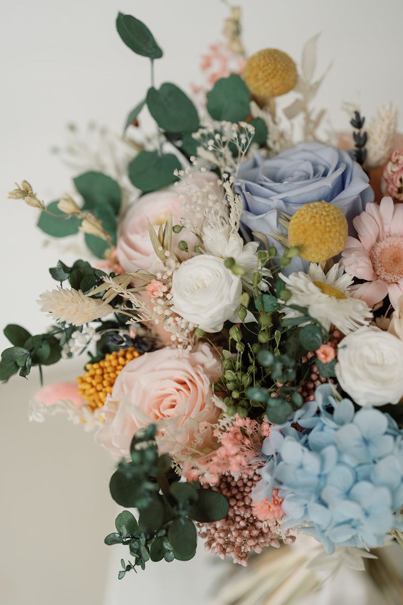 Pastel garden style dried and preserved bridal bouquet with roses, daisies, hydrangeas and eucalyptus