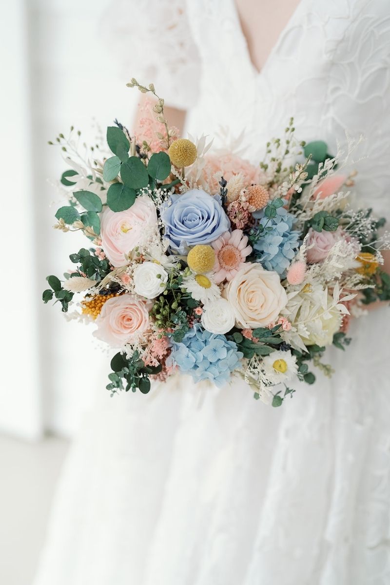 Pastel garden style dried and preserved bridal bouquet with roses, daisies, hydrangeas and eucalyptus