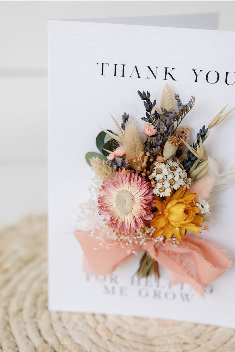 a colourful mini dried flower bunch bouquet hand tied onto a white card which reads "thank you for helping me grow"